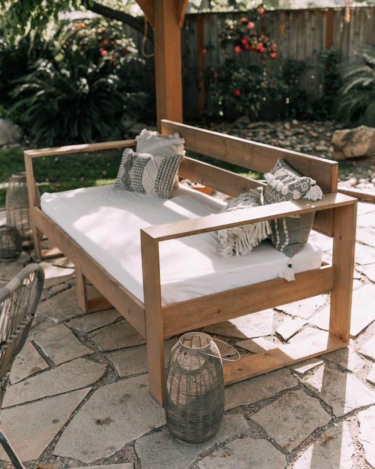 Wooden Outdoor Daybed With Gray Lantern Accent