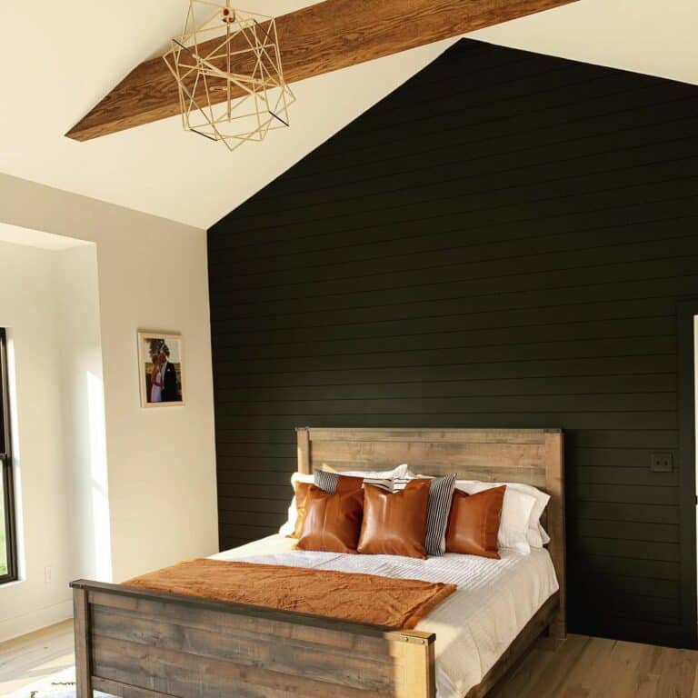 Bedroom With Black Shiplap Wall and Exposed Wood Beams