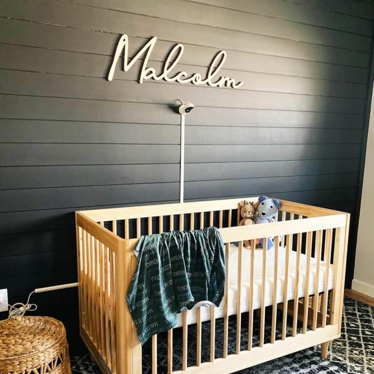 Nursery With Black Shiplap Walls and Name Sign