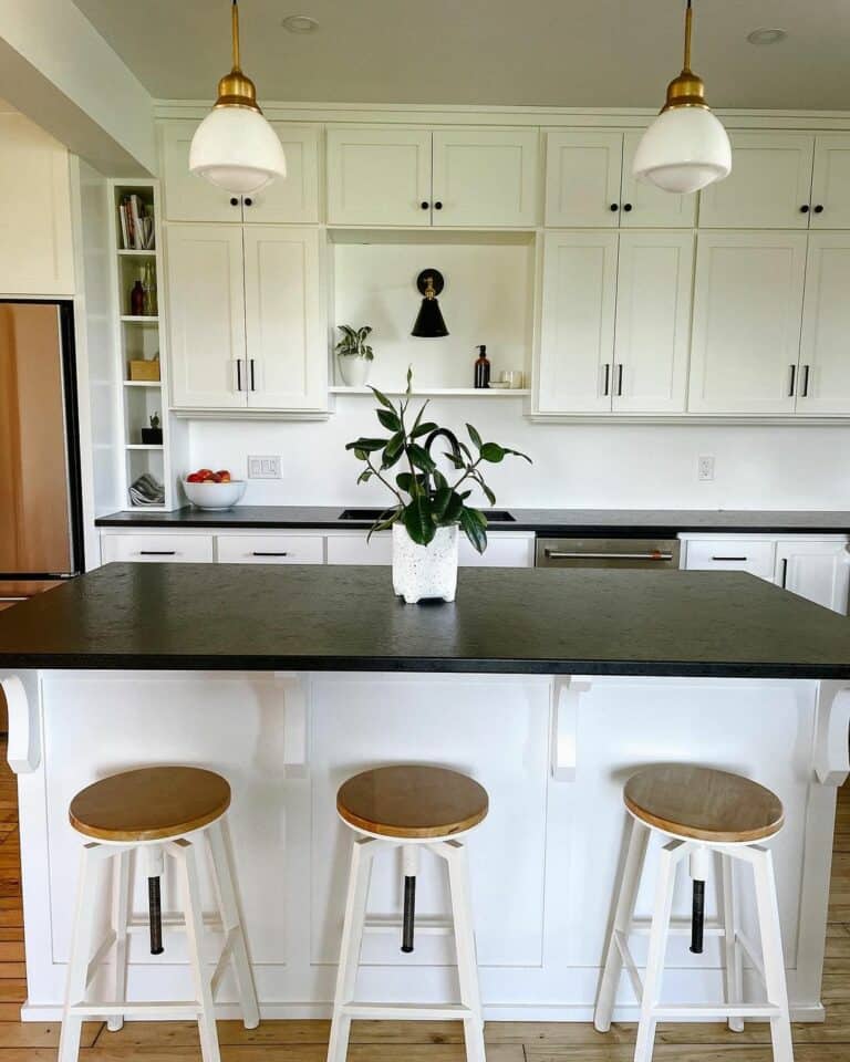 Simple Kitchen With Black Counters and Wooden Stools