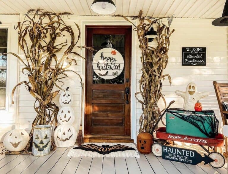 White Farmhouse Porch With Carved Pumpkins