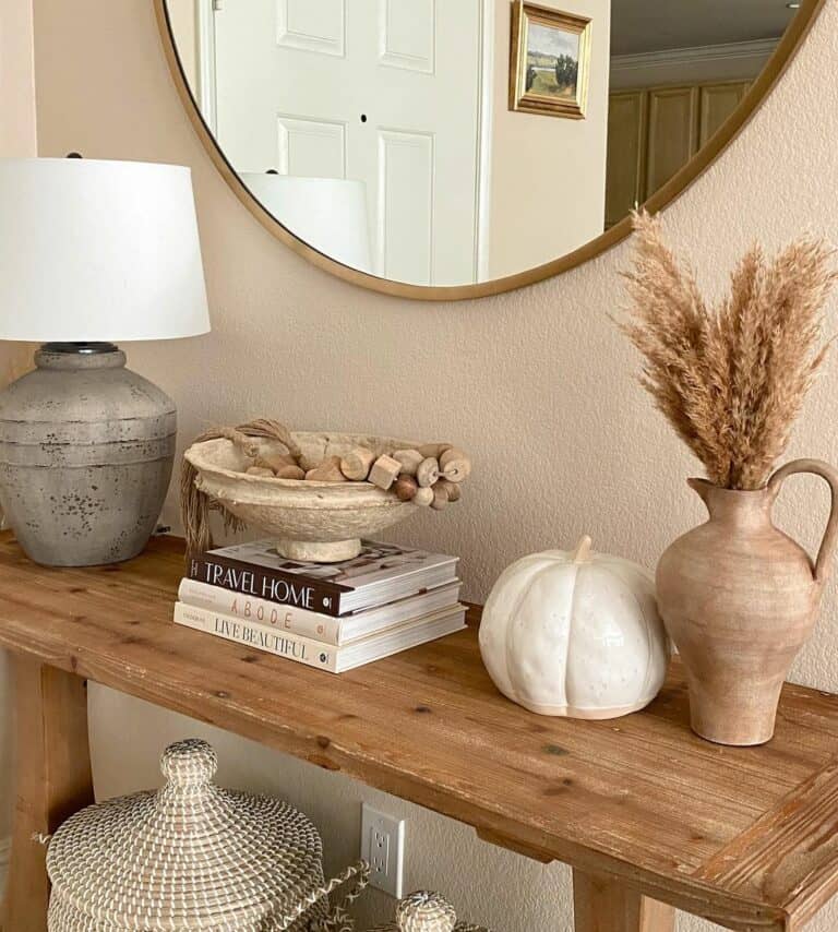 Round Mirror Mounted Above a Wooden Console Table