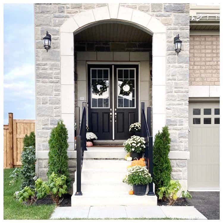 Covered Stone Porch With Black Doors